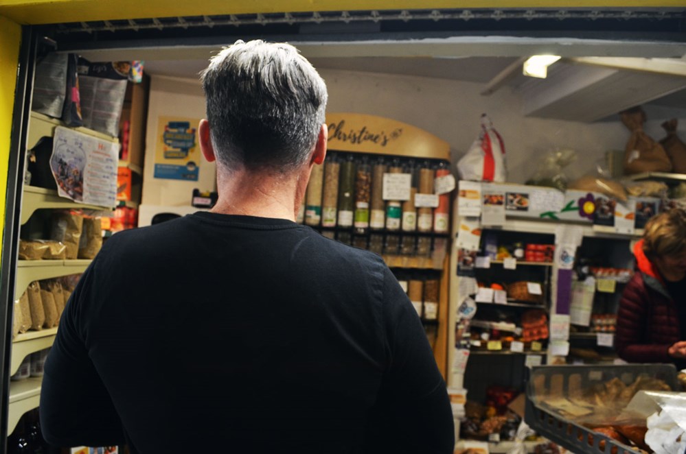 behind shot of man walking into christine's sustainable supermarket