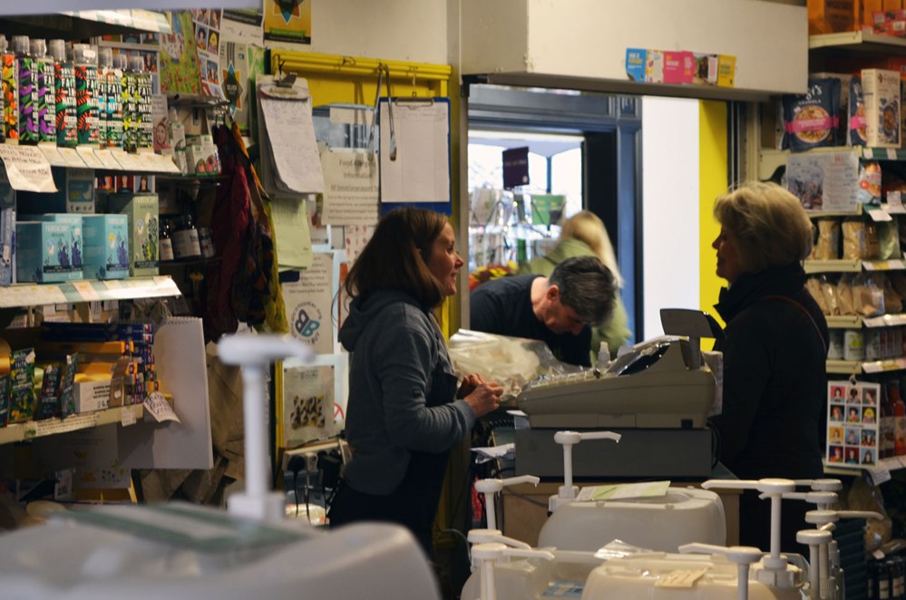 woman serving customers in a health food store